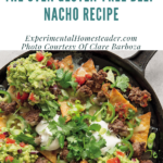 The beef nachos ready to serve in a cast iron skillet.