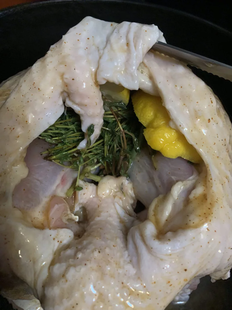 The turkey breast showing the herbs and lemons in between the skin and meat.