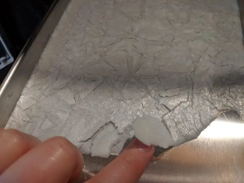 A finger lifting up the freeze dried milk.