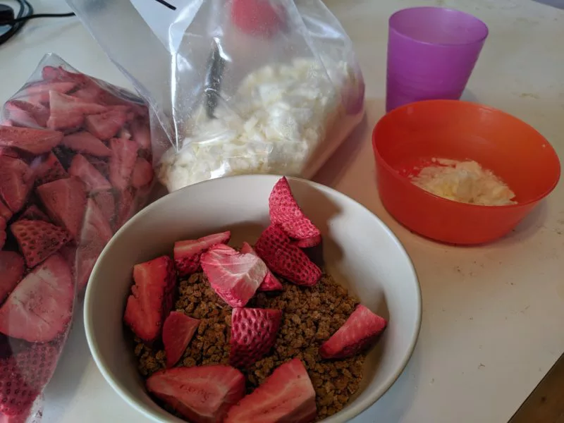 Freeze dried strawberries in a bowl on top of cereal.