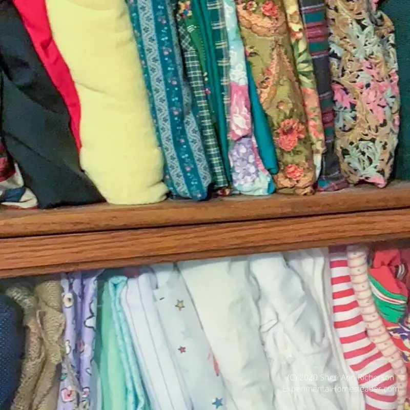 Fabric folded and organized on a shelf.