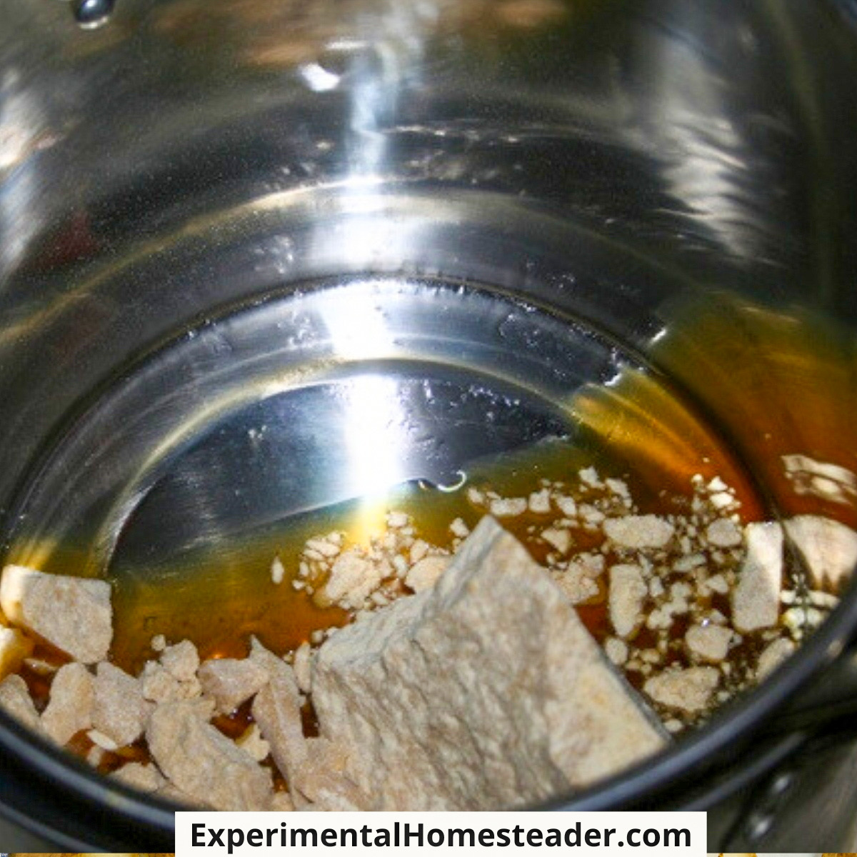 Cocoa butter beginning to melt in a stainless steel double boiler.