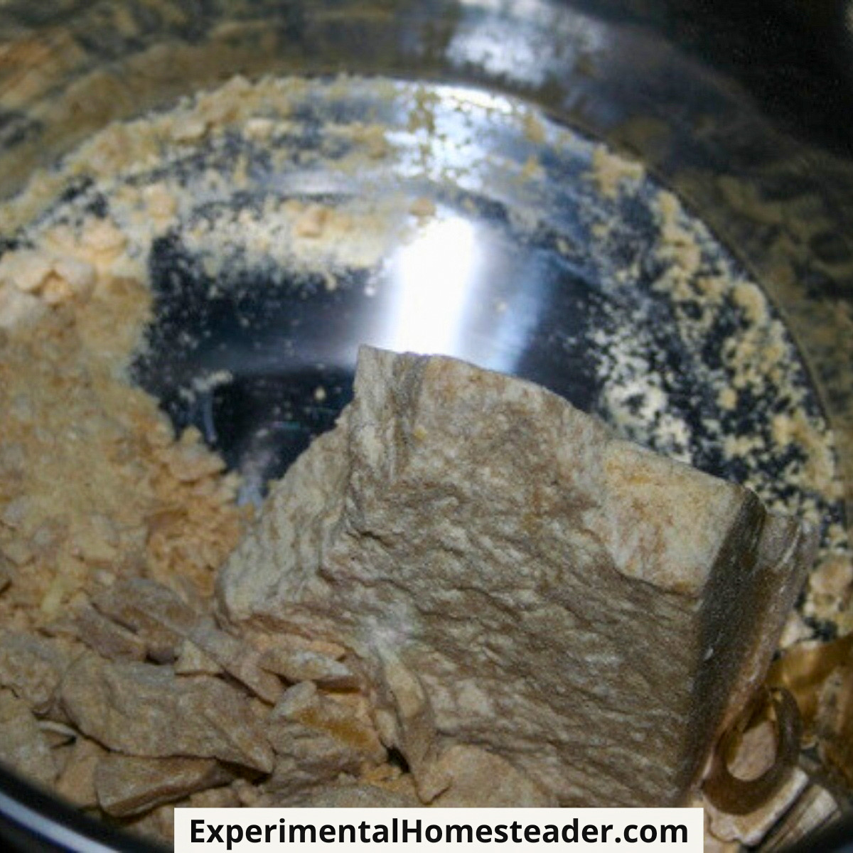 Solid chunks of cocoa butter placed in the top pan of a double boiler.