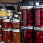 Jars of home canned food on a shelf.