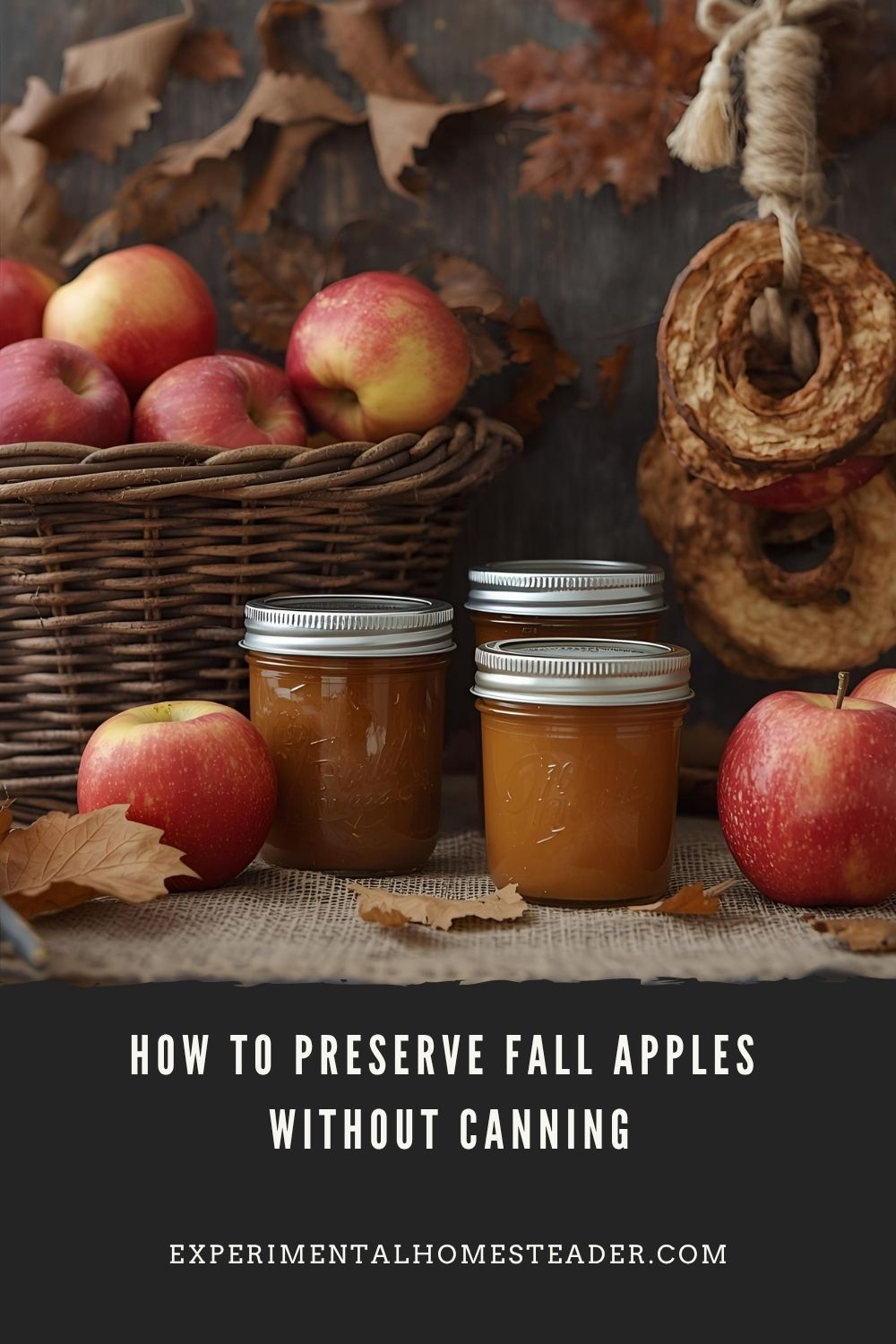 A wicker basket filled with red apples beside jars of homemade apple butter and dried apple rings, styled with autumn leaves on a burlap-covered table.
