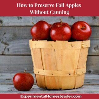 A wooden basket filled with red apples against a rustic weathered wood backdrop, symbolizing fall harvest and simple homestead living.